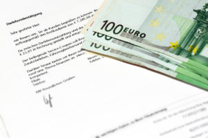 Einige hundert Euro Scheine auf einem Kreditvertrag