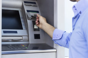 Ein Mann zieht Geld am Geldautomat