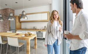 Ein junges Paar steht in einer hellen, modernen Küche