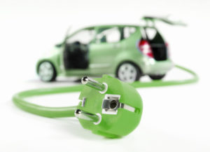 Ein grünes Stromkabel an dessen Ende ein grün lackiertes Auto hängt